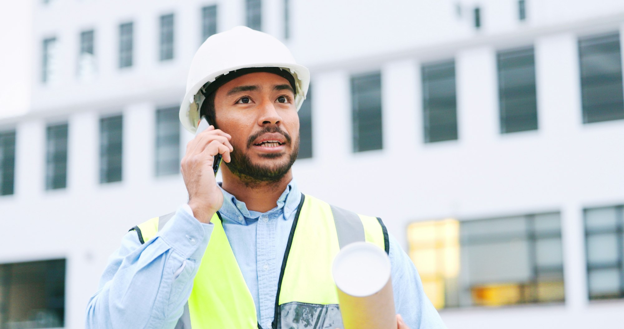 Civil engineer on a phone call while at a construction site discussing a strategy and plan to work